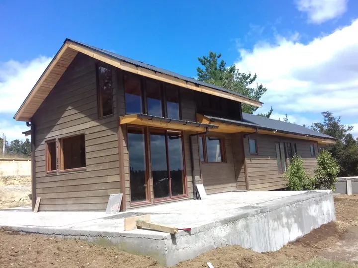 Casa La Goleta I con revestimiento de madera y grandes ventanales, construida por Biohabitat